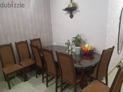 Oval shaped wooden dining table with 8 chairs