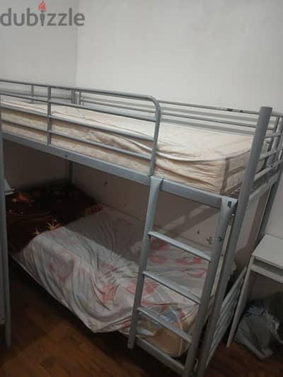 Two bedrooms, two iron bunk beds with mattresses, and a dining table w