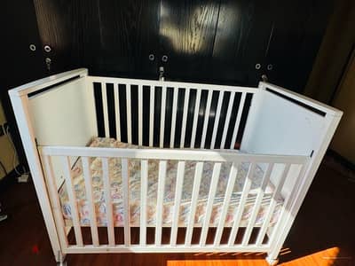 Baby crib with adjustable side rail