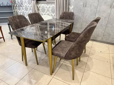 Dining table with 5 chairs and gold steel legs.