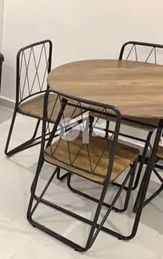 Wooden round table with four chairs . .